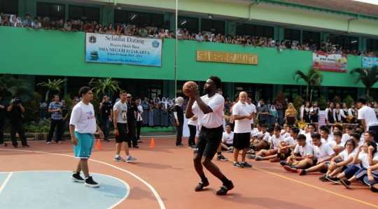 Aksi pemain NBA Jaylen Brown main basket dengan anak-anak