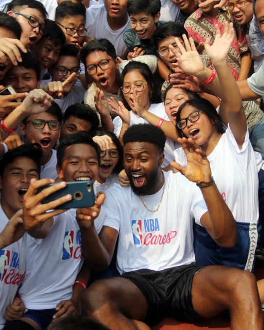 Aksi pemain NBA Jaylen Brown main basket dengan anak-anak