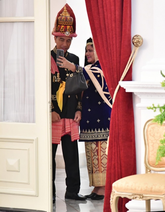 Gaya Jokowi dan Iriana selfie dengan busana daerah di balik pintu istana