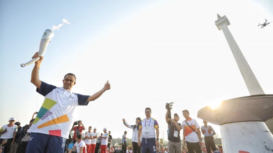 Aksi Anies Baswedan saat bawa obor di puncak kirab Asian Games 2018