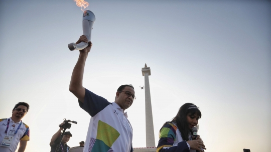 Aksi Anies Baswedan saat bawa obor di puncak kirab Asian Games 2018