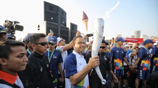 Aksi Anies Baswedan saat bawa obor di puncak kirab Asian Games 2018