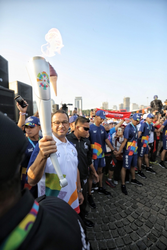 Aksi Anies Baswedan saat bawa obor di puncak kirab Asian Games 2018