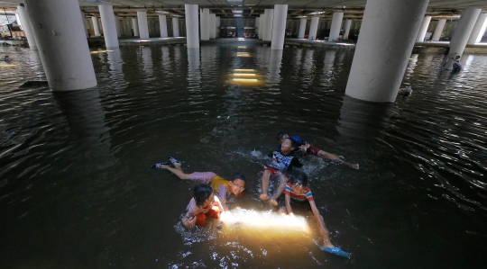 Belum surut, genangan di Terowongan Apron jadi tempat berenang anak-anak