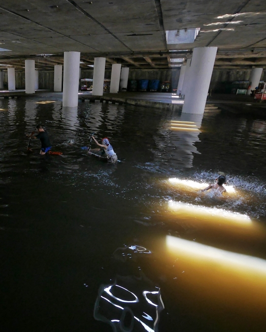 Belum surut, genangan di Terowongan Apron jadi tempat berenang anak-anak