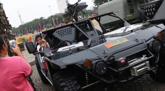 Gaya pengunjung berpose dengan alutsista TNI di Monas