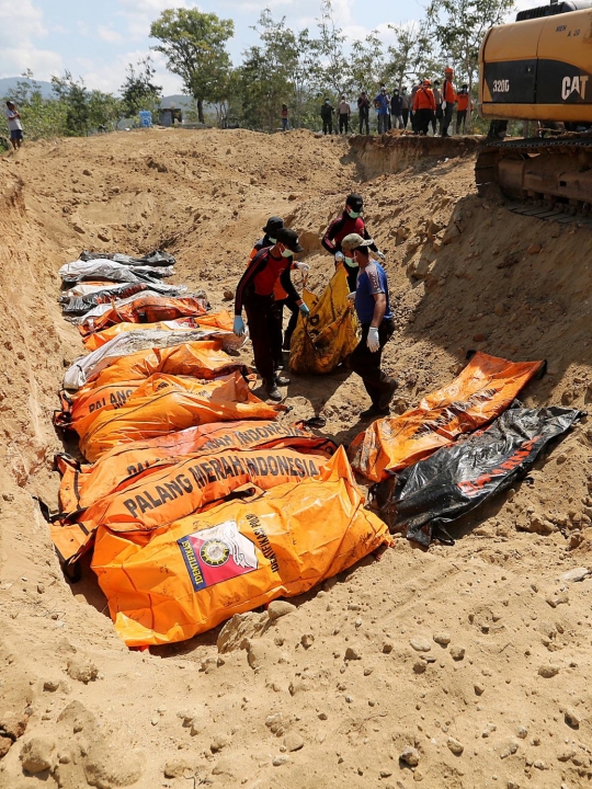 Dibantu eskavator, puluhan korban gempa dan tsunami Palu dikubur massal