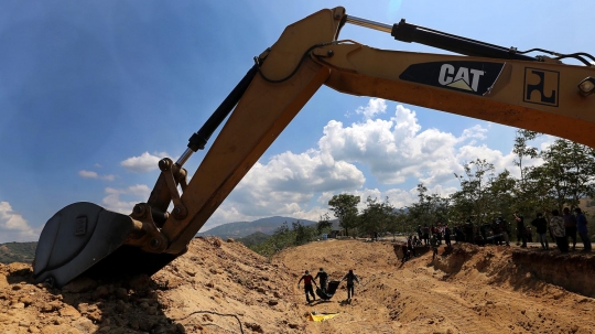 Dibantu eskavator, puluhan korban gempa dan tsunami Palu dikubur massal