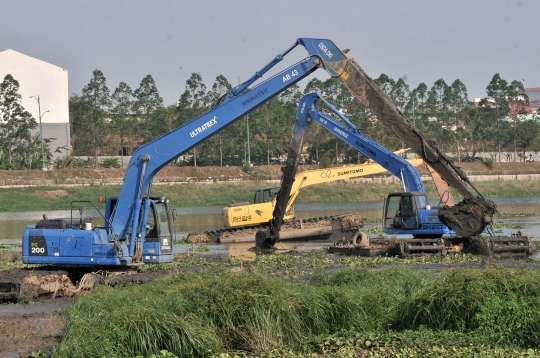 Pengerukan lumpur dan tanaman liar di Kanal Banjir Timur