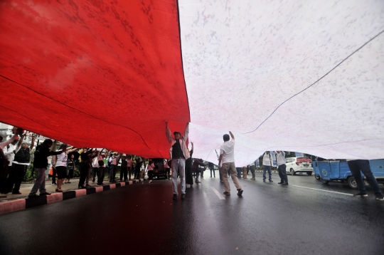 Tolak Reuni 212, Massa Bentangkan Bendera Merah Putih Raksasa di depan Balai Kota