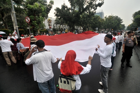 Tolak Reuni 212, Massa Bentangkan Bendera Merah Putih Raksasa di depan Balai Kota