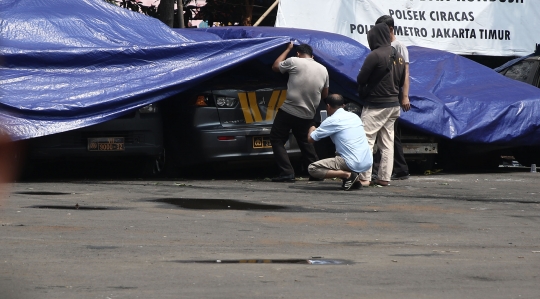 Petugas Melihat Kondisi Kendaraan yang Rusak di Polsek Ciracas