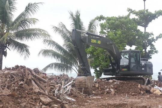 Alat Berat Bersihkan Puing Bangunan Terdampak Tsunami di Carita