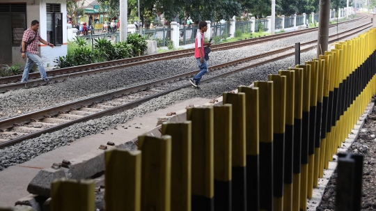 Malas Gunakan JPO, Pejalan Kaki Nekat Panjat Pagar Pembatas Perlintasan Kereta