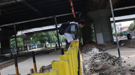 Malas Gunakan JPO, Pejalan Kaki Nekat Panjat Pagar Pembatas Perlintasan Kereta