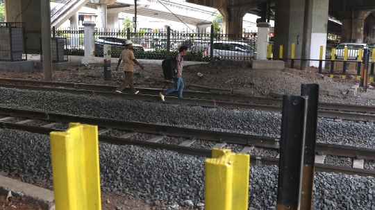 Malas Gunakan JPO, Pejalan Kaki Nekat Panjat Pagar Pembatas Perlintasan Kereta