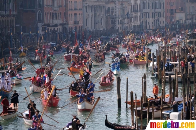 Para peserta saat berpartisipasi dalam parade perahu unik yang digelar di Grand Canal di Kota Venesia, Italia (17/2). Parade ini digelar untuk menandai awal musim karnaval di kota tersebut.