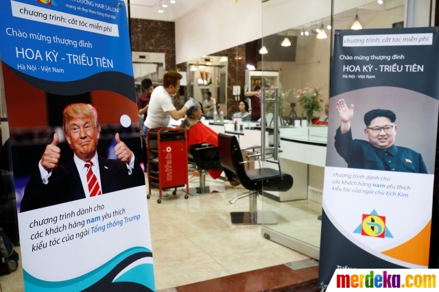 Banner promosi dengan menggratiskan potong rambut bergaya mirip Kim Jong-un dan Trump terpasang di depan barbershop Tuan Duong.