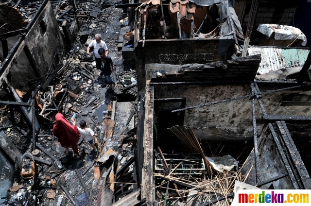Warga melihat kondisi permukiman yang ludes dilalap api di kawasan Krukut, Tamansari, Jakarta, Selasa (26/2). Sedikitnya 30 rumah di 4 RT hangus setelah api membakar kawasan padat penduduk tersebut pada pukul 9.50 WIB tadi. 