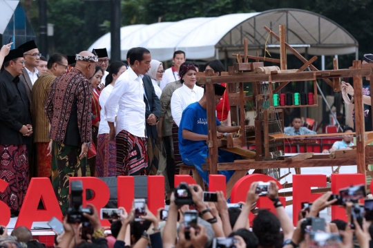 Aksi Jokowi Jajal Alat Tenun di Festival Sarung Indonesia 2019