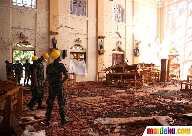 Petugas melakukan penyelidikan di dalam Gereja St Sebastian yang porak-poranda setelah dihantam serangan bom di Negombo, Sri Lanka, Senin (22/4).
