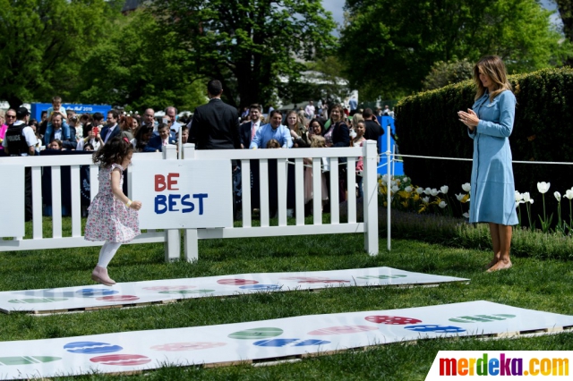 Melania Trump menyambut seorang anak yang mengikuti lomba menggelindingkan telur Paskah di halaman Gedung Putih, Washington, Senin (22/4).