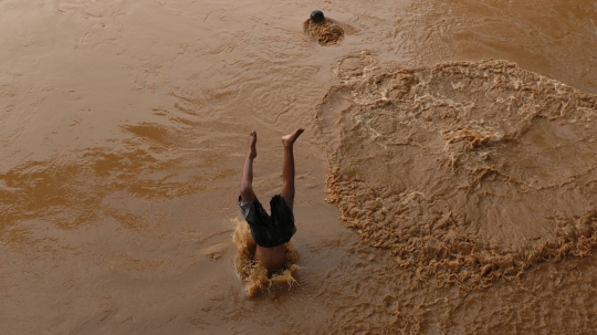 Kenekatan Anak-anak Berenang di Sungai Ciliwung yang Meluap