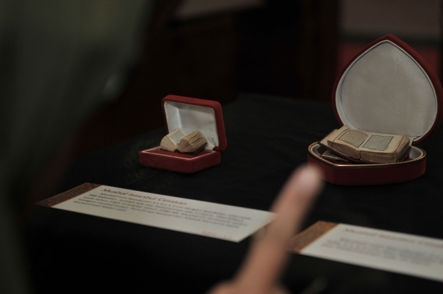Pengunjung melihat Alquran terkecil yang dipamerkan di Museum Bayt Al-Quran, Jakarta, Minggu (19/5).  