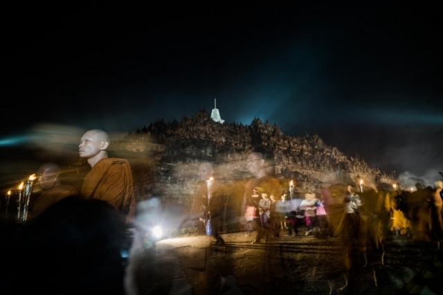 Umat Buddha berpawai melewati Candi Borobudur selama perayaan Waisak di Magelang, Jawa Tengah, Minggu (19/5).