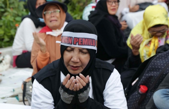 Massa Buka Puasa dan Salat Maghrib di Depan Kawat Berduri Bawaslu