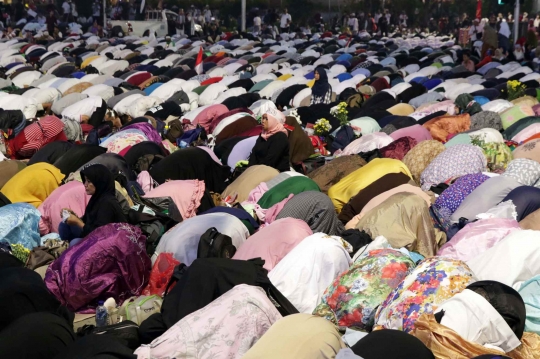 Massa Buka Puasa dan Salat Maghrib di Depan Kawat Berduri Bawaslu