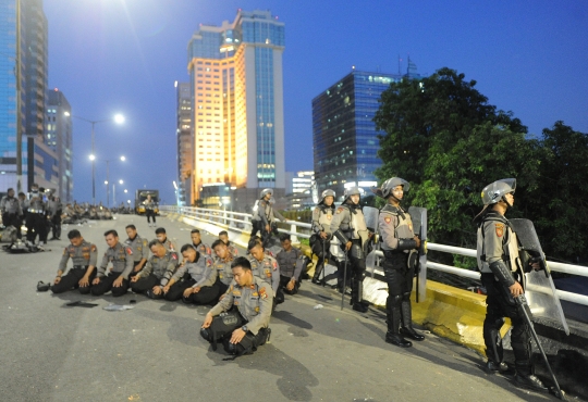 Polisi Salat Magrib Berjemaah di Tengah Tugas Pengamanan
