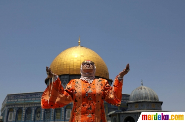 Seorang wanita muslim berdoa di depan Kubah Batu pada hari Jumat terakhir bulan suci Ramadan.