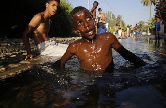 Keseruan Anak-Anak Palestina Berenang di Saluran Irigasi