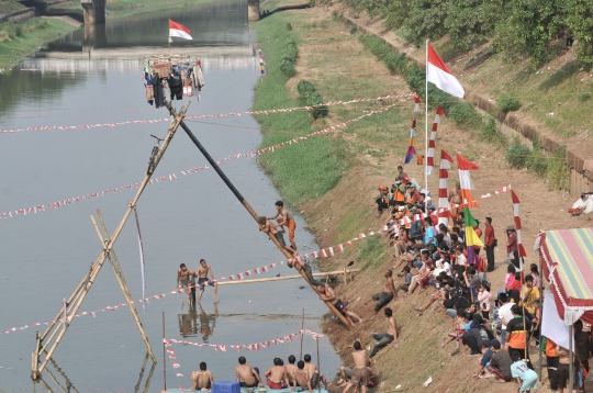 Serunya Lomba Panjat Pinang di Kanal Banjir Timur