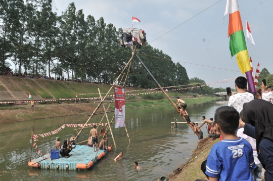 Serunya Lomba Panjat Pinang di Kanal Banjir Timur