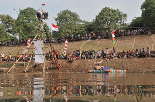 Serunya Lomba Panjat Pinang di Kanal Banjir Timur