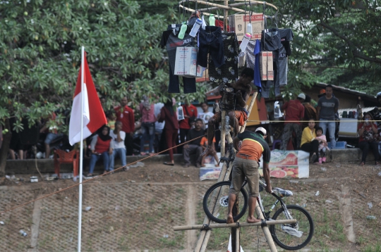 Serunya Lomba Panjat Pinang di Kanal Banjir Timur