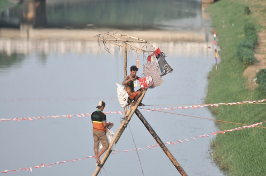 Serunya Lomba Panjat Pinang di Kanal Banjir Timur