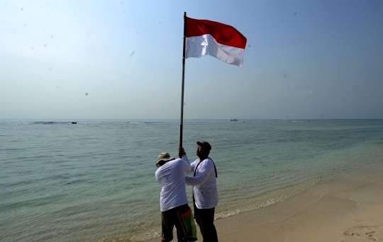 Aktivis Gelar Upacara Bendera Menghadap Laut dan Bersih Pantai