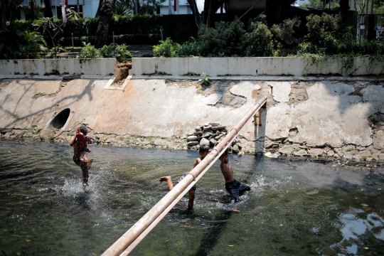 Kurangnya Lahan Bermain, Anak-Anak Berenang di Kali Kotor