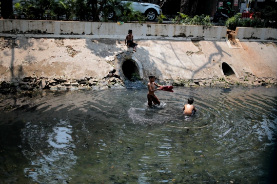 Kurangnya Lahan Bermain, Anak-Anak Berenang di Kali Kotor