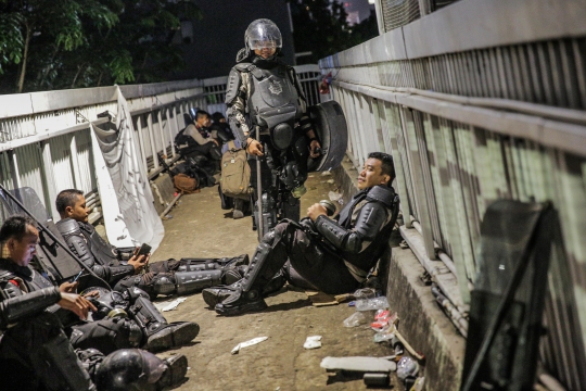 Ketika Polisi Melepas Lelah Usai Bubarkan Pendemo di DPR