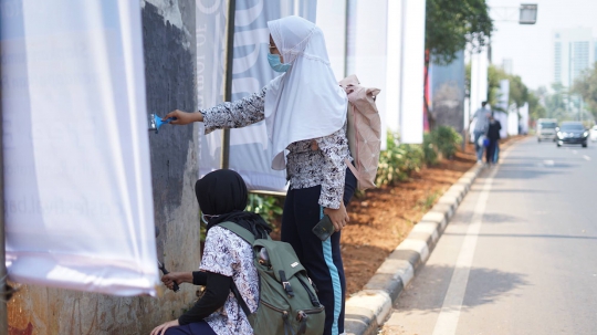 Aksi Pelajar Hapus Coretan Sisa Vandalisme Unjuk Rasa di Senayan