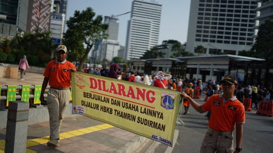 Aksi Satpol PP Bentangkan Spanduk Larangan PKL Berjualan di Car Free Day