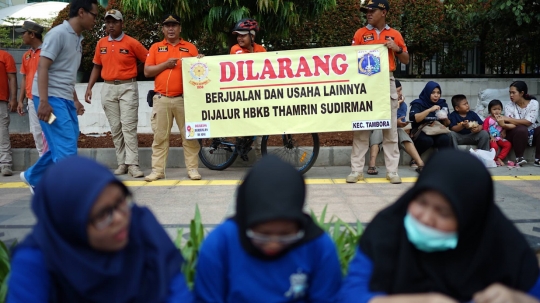 Aksi Satpol PP Bentangkan Spanduk Larangan PKL Berjualan di Car Free Day