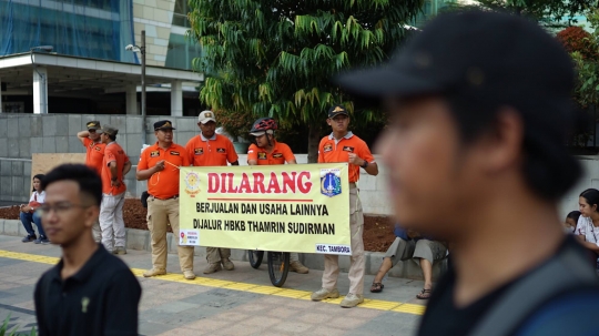 Aksi Satpol PP Bentangkan Spanduk Larangan PKL Berjualan di Car Free Day