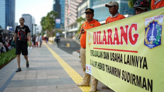 Aksi Satpol PP Bentangkan Spanduk Larangan PKL Berjualan di Car Free Day