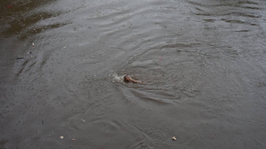 Hujan Deras, Anak-Anak Ini Nekat Berenang di Sungai Ciliwung