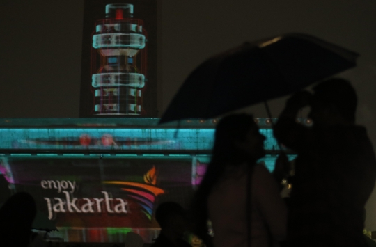 Hujan, Warga Tetap Antusias Saksikan Video Mapping Tahun Baru 2020 di Monas